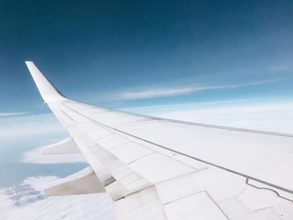 View of an airplane wing above the clouds from the window seat