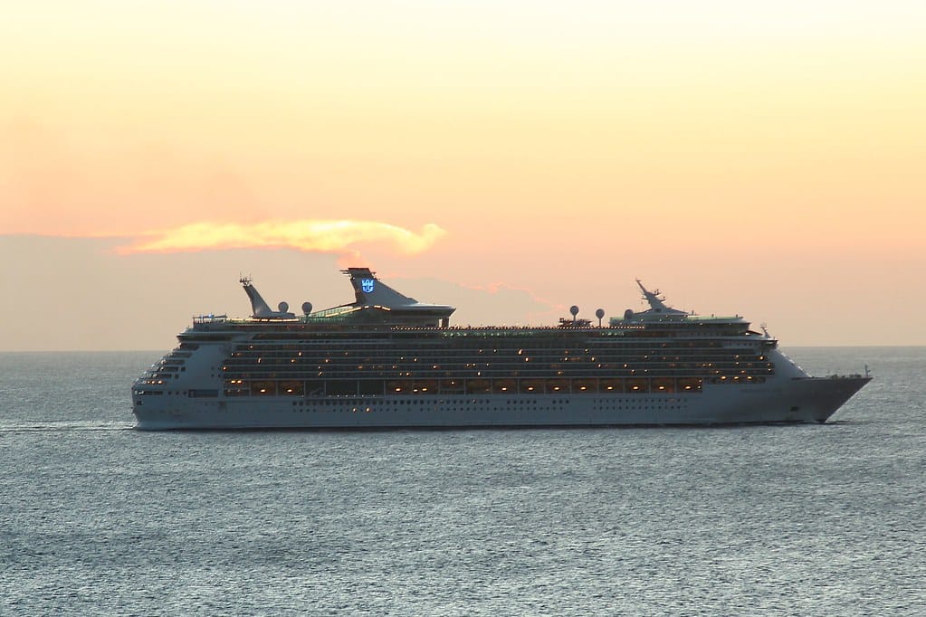 Cruise ship sailing on the open ocean at sunset