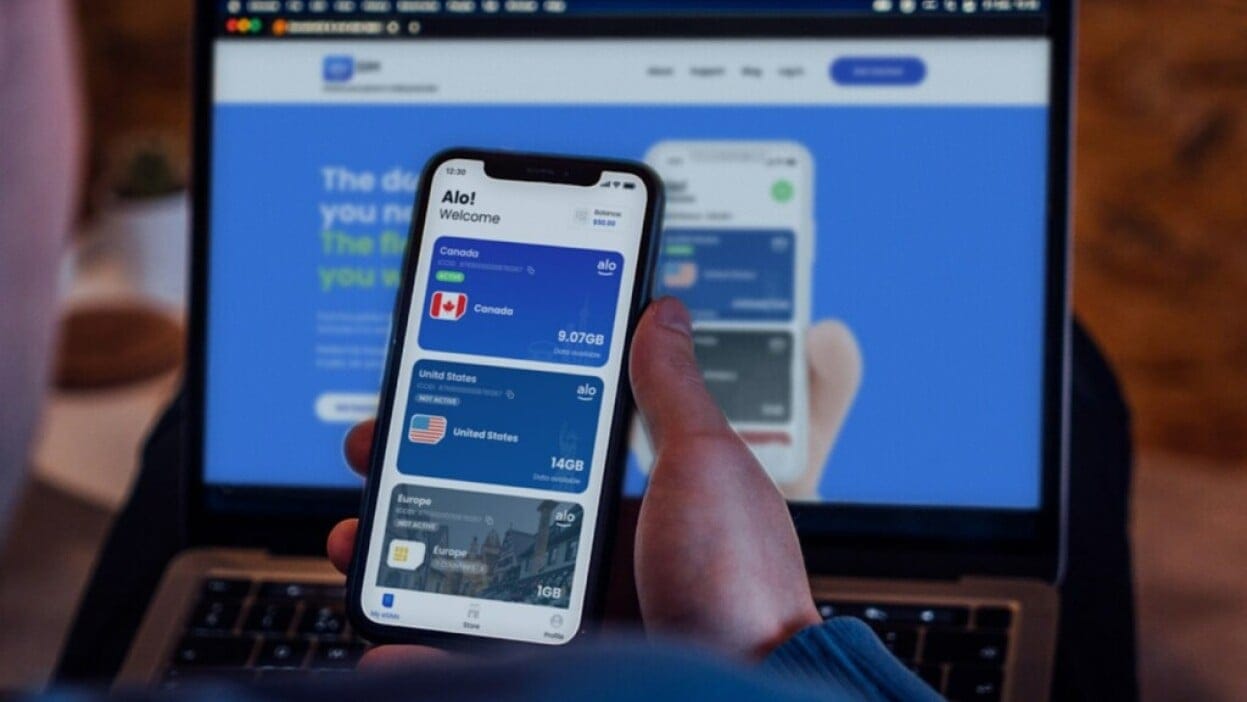 Smartphone showing an eSIM travel data plan next to a passport and travel essentials
