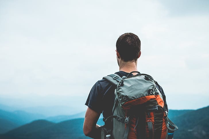 Traveller with a backpack overlooking a mountain landscape on a US road trip